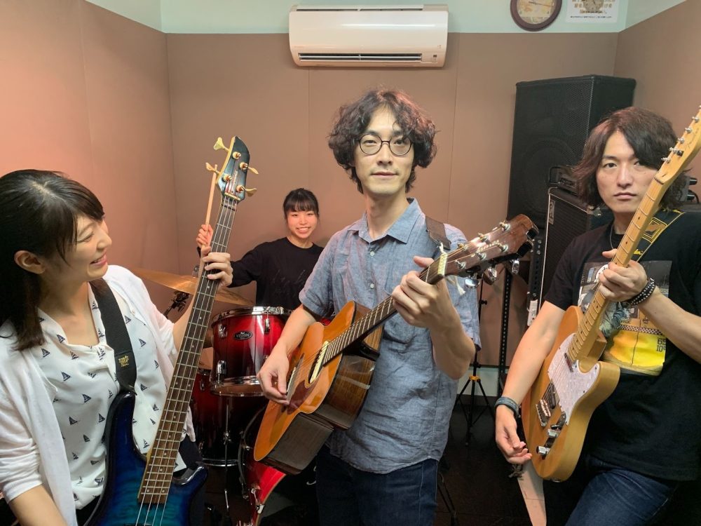 画像:ウェブサイト立ち上げ当時は友人や関係者がスタジオに集まって素材写真を撮りました。私も生徒役で参加しました(写真中央)